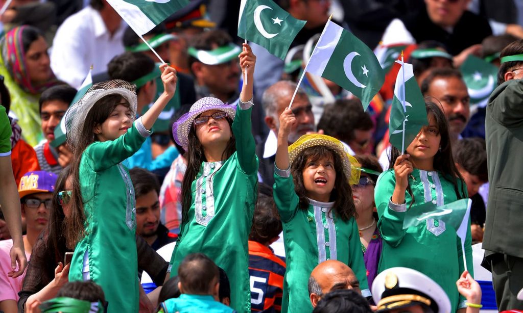 Young Pakistani children wave national flags as they watch the Pakistan Day military parade in Islamabad on March 23, 2016. Pakistan National Day commemorates the passing of the Lahore Resolution, when a separate nation for the Muslims of The British Indian Empire was demanded on March 23, 1940. / AFP PHOTO / AAMIR QURESHI